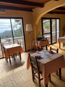 a dining room with tables and chairs and windows at Auberge Coralli in Sartène +29 photos