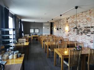 un ristorante con tavoli e sedie in legno e un muro di mattoni di Strand Hotell a Vänersborg