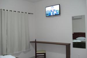 a room with a tv on the wall with a bed at Brisa Parque Hotel in Erechim