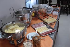 um buffet com comida numa mesa com pratos de comida em Brisa Parque Hotel em Erechim