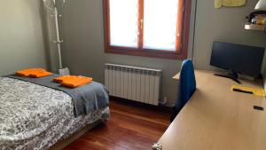 - une chambre avec un lit et une télévision à écran plat dans l'établissement Amezola 2- Habitación con baño exterior de uso privado en casa compartida, à Bilbao