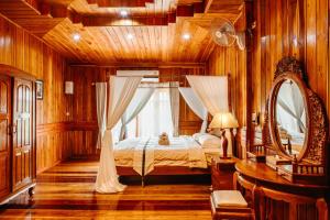 a bedroom with a bed with a window and a mirror at Baan Maneekan in Sukhothai