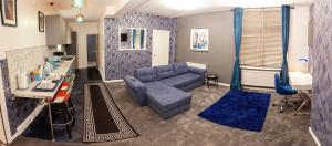 Cosy Luxury Suite Jewellery Quarter - Birmingham في برمنغهام: غرفة معيشة مع أريكة زرقاء وطاولة