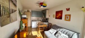 a living room with a couch and a kitchen at Studio Cabine - Port Camargue - Bord de Mer in Le Grau-du-Roi