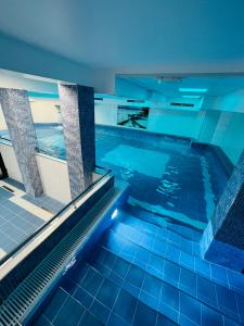 an indoor swimming pool with blue tile floors and a swimming pooliterator at Pensjonat Pod Kogutami in Bieliny
