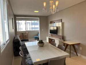 sala de estar con mesa y comedor en Apartamento Central Super Localização, en Torres