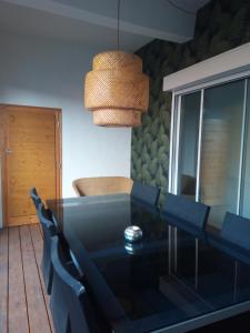 a dining room with a black table and chairs at Thuir/Appartement avec loggia privative in Thuir