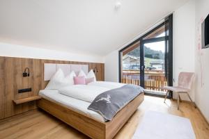 a bedroom with a large bed and a large window at My Dahoam in Eben im Pongau