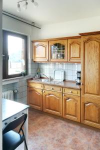 a kitchen with wooden cabinets and a sink at Haus Hirt-Nettetal in Nettetal
