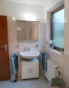 La salle de bains est pourvue d'un lavabo et d'un miroir. dans l'établissement Haus Hirt-Nettetal, à Nettetal