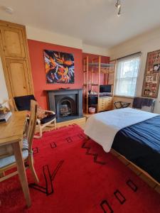 a bedroom with a bed and a table and a fireplace at Alma House Bed and Breakfast in Newbury