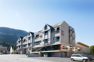 a building with a car parked in a parking lot at Hotel am Garnmarkt in Götzis