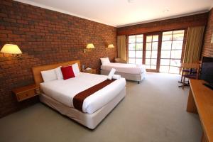 A bed or beds in a room at Grange Burn Motel