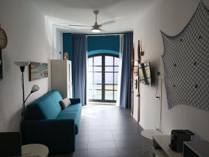 a living room with a blue couch and a door at savonaamare 2.0 in Savona