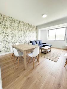 sala de estar con mesa, sillas y sofá en Apartamento San Isidoro, en Santiago de Compostela