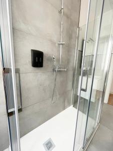 La salle de bains est pourvue d'une douche et d'une porte en verre. dans l'établissement Apartamento San Isidoro, à Saint-Jacques-de-Compostelle