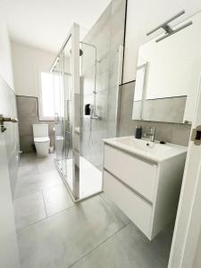 La salle de bains blanche est pourvue d'un lavabo et d'une douche. dans l'établissement Apartamento San Isidoro, à Saint-Jacques-de-Compostelle