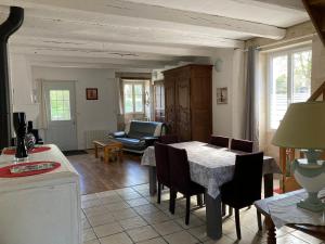 a kitchen and living room with a table and chairs at Charmante maison dans la vallée de la Charente in Voulême