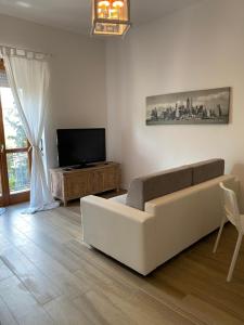 a living room with a couch and a flat screen tv at UNIQUE ROOMS in Verona