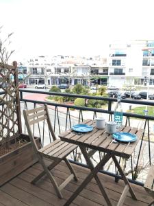 una mesa de madera y una silla en un balcón con vistas en Appartement Royan, 200 m de la PLAGE en Royan