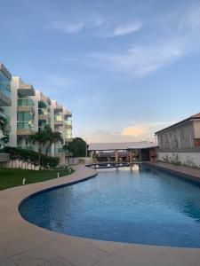 a large swimming pool in front of a building at Residêncial mar e sol in Conde