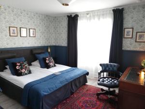 una camera da letto con un letto, una sedia e una scrivania di Strand Hotell a Vänersborg