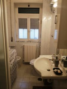 uma casa de banho branca com um lavatório e um WC em La Casa nel Vico em Locorotondo