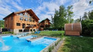 a log house with a swimming pool in the yard at Chalets et Spa Lac Saint-Jean in Chambord