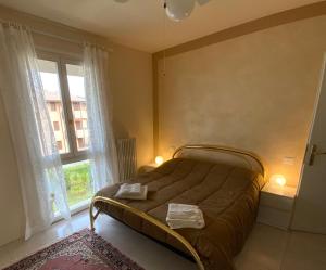 un letto in una camera con una grande finestra di Elena Apartment Residence a Bardolino