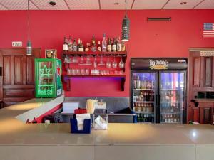 un bar con una pared roja y una barra con bebidas en Big Daddy's Beach Club & Hotel, en Puerto Armuelles