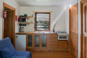 cocina con armarios de madera, fregadero y ventana en Noosa Rural Retreat, en Pomona