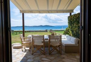 a patio with a table and chairs and a couch at Alemar Estates Ouranoupolis in Ouranoupoli