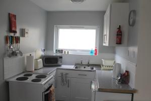 a kitchen with a stove and a sink and a window at 78 Florida Holiday Park in Hemsby