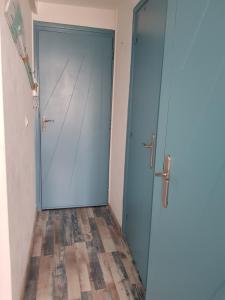 a blue door in a room with a wooden floor at Appartement Royan, 200 m de la PLAGE in Royan