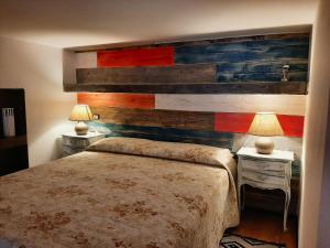 een slaapkamer met een houten muur met een bed en twee lampen bij La Cabina in Chiavari