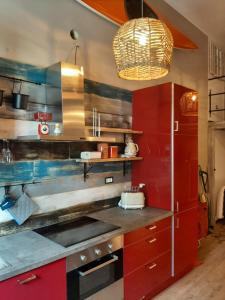 een keuken met rode kasten en hangend licht bij La Cabina in Chiavari