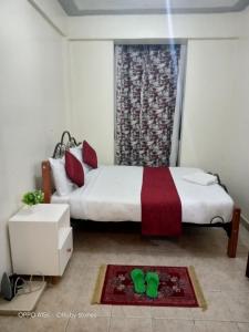 1 dormitorio con 1 cama y una ventana con zapatos verdes en el suelo en Rubistones en Naivasha