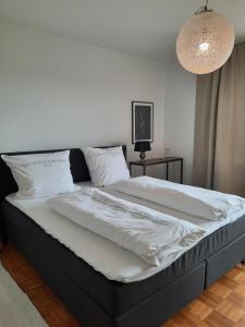 Una cama con sábanas blancas y almohadas en un dormitorio en Idyll, en Welferode