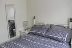 1 dormitorio con cama y espejo en 78 Florida Holiday Park en Hemsby