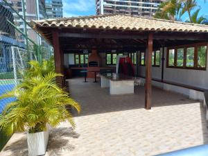 um gazebo com uma palmeira ao lado de um edifício em SEU CANTINHO NA BARRA no Rio de Janeiro