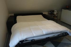 a bed with a black frame and white sheets at O'bon'Eure in Bray