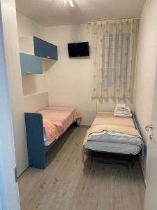 a small room with two beds and a tv at Appartamento Sabbia & Conchiglie in Marotta