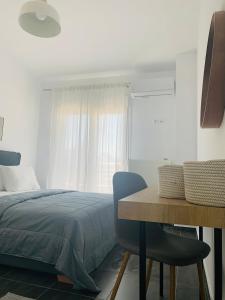 a bedroom with a bed and a table and a window at Elegant Apartment Keramoti in Keramoti