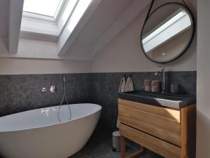 a bathroom with a sink and a tub and a mirror at Picobello Lago in Mandello del Lario