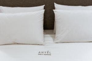 a white bed with white pillows on it at ANTEL Suites & Apartments in Chania