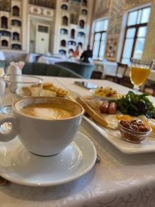 ブハラにあるリャビ ハウズ ホテルのコーヒーと食器を一杯付けたテーブル +19枚の写真