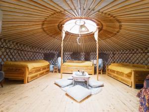 a room with two beds and a table in a yurt at Yourte A bourlon in Bourlon