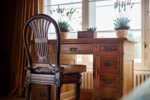 a wooden chair sitting in front of a desk with potted plants at Garden Cottage Villa Lichtenstein - Your Austrian Home in Altaussee