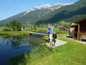 a group of people standing on a dock near a river at Apart Toscana in Neustift im Stubaital
