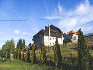a large house on top of a hill with trees at Divčibarski Vajati in Divčibare